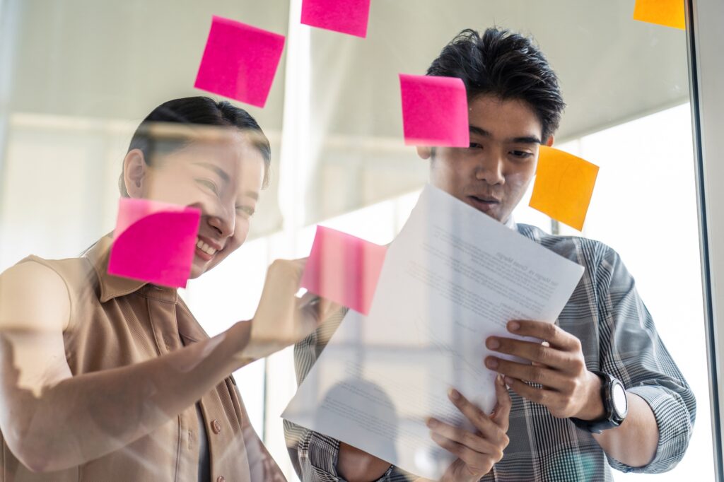 Asian young business people brainstorm to solve problem and planning new challenge topic.